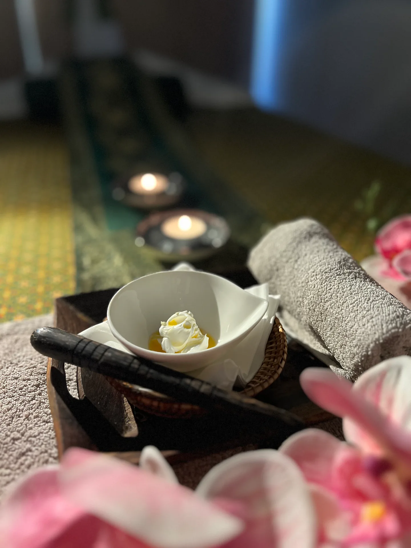 Thai herbal body-care tray with towels and candlelight